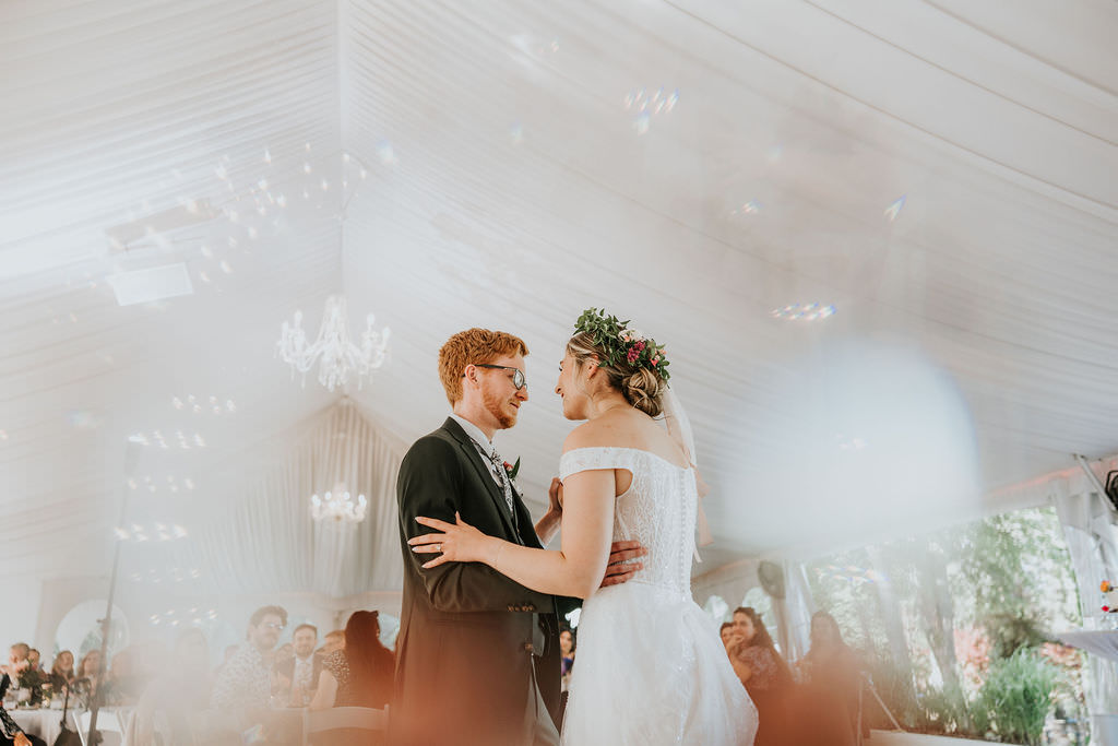 Bride and groom first dance in classy wedding reception tent