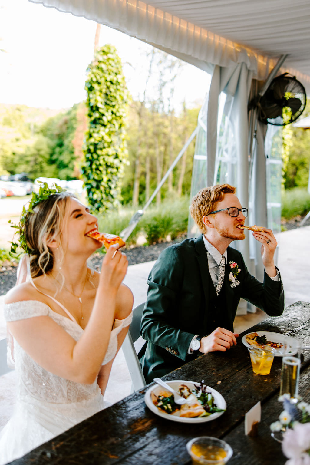 Bride and groom enjoying pizza at their wedding reception